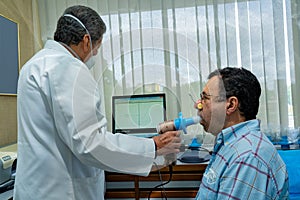 Mature man performing pulmonary function test and spirometry