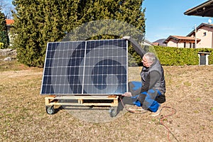 Mature man with photovoltaic solar panel in the garden