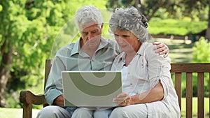 Mature man placing her arm around the neck of his wife