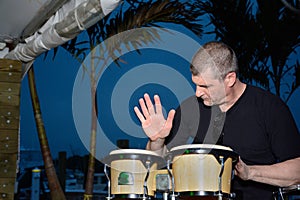 Mature man playing bongos outdoors