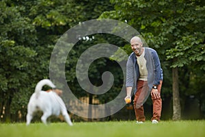 Mature Man Playing with Dog in Park