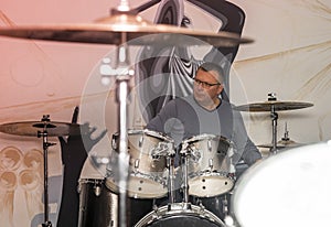 Mature man playing at drums kit