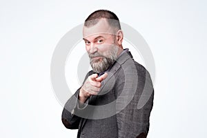 Mature man pointing to camera like choosing you. Good advice concept.