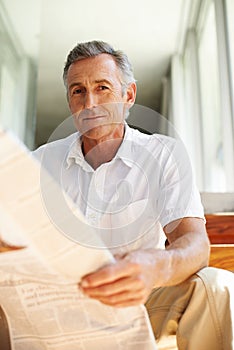 Mature, man and portrait with newspaper in home for morning reading with current events, politics or international. Male