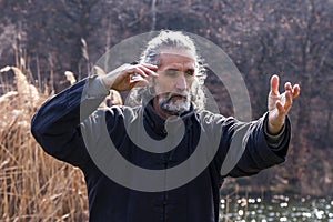 Mature man practicing Tai Chi discipline outdoors