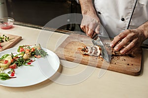 Mature man professional chef cooking meal indoors