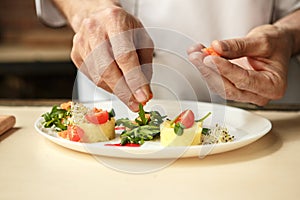 Mature man professional chef cooking meal indoors