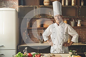 Mature man professional chef cooking meal indoors