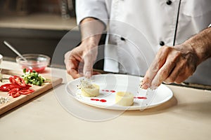 Mature man professional chef cooking meal indoors