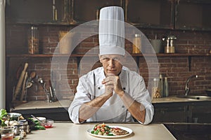 Mature man professional chef cooking meal indoors