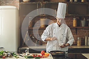 Mature man professional chef cooking meal indoors