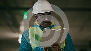 Mature man professional worker engineer builder with protective helmet inspects room writes data in notebook