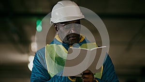 Mature man professional worker engineer builder with protective helmet inspects room writes data in notebook