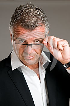 Mature man putting on glasses photo