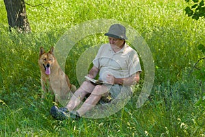 Mature man reading an interesting book to young dog