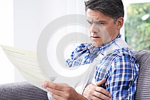 Mature Man Reading Letter About Injury