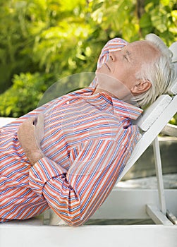 Mature Man Reclining On Lounge Chair