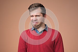 Mature man in red sweater looking with disbelief expression