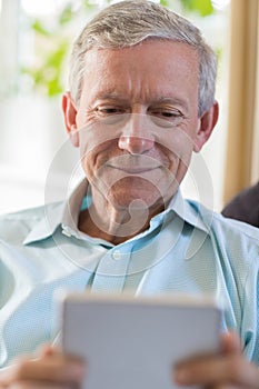 Mature Man Using Digital Tablet At Home