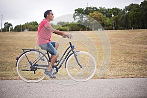 Mature man riding bicycle in countryside