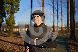 Mature man running in the park with headphones
