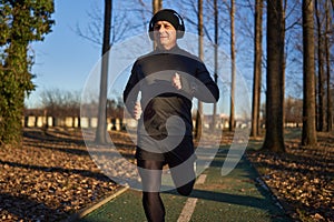 Mature man running in the park with headphones