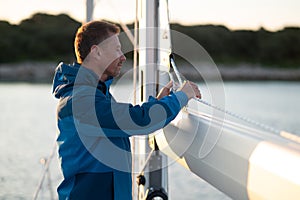 Mature man sailing on the yacht and looking busy