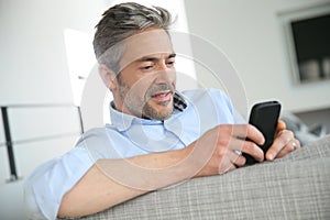 Mature man sending sms with smartphone