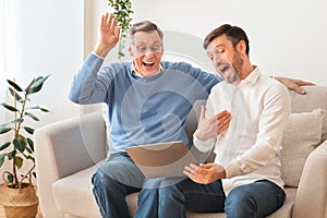 Mature Man And Senior Father Using Laptop Laughing Sitting Indoor