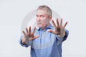 Mature man showing refusal sign. It is not for me