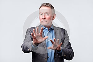 Mature man showing refusal sign. It is not for me