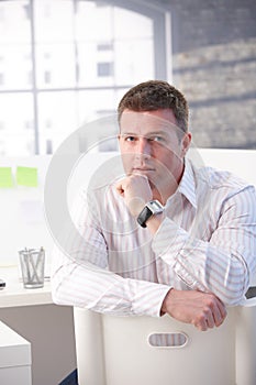 Mature man sitting in office thinking