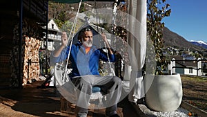 Mature man sitting under the porch