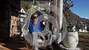 Mature man sitting under the porch