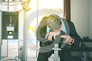 Mature man sleeping on gym cycling in fitness center