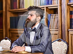 Mature man in smart suit thinks about literature.