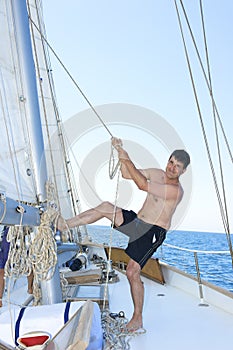 Mature man smiling while hoisting the sail photo
