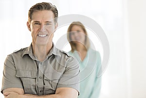 Mature Man Smiling With Woman In Background