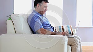 Mature man on the sofa using his laptop