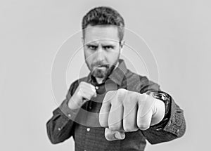 Mature man stand in offensive fighting position with clenched fist selective focus, power