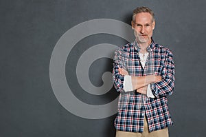 Mature man standing against grey wall
