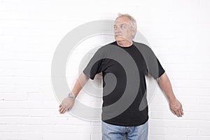 Mature man standing against a white wall background