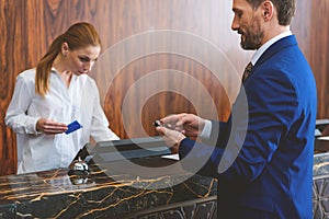 Mature man standing at check-in desk