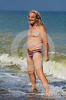 Mature man sunbathing on the sea beach.