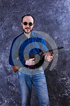 Mature man in sunglasses with tommy gun