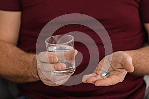 Mature man taking pill, closeup