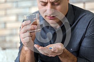 Mature man taking pill at home