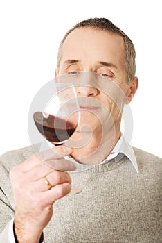 Mature man tasting red wine