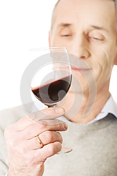 Mature man tasting red wine