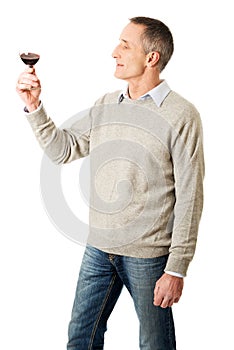 Mature man tasting red wine